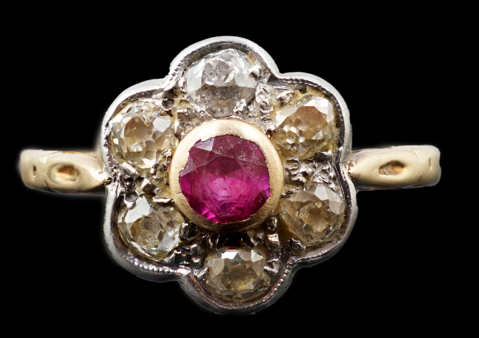 A gold and platinum, ruby and millegrain set diamond flower head cluster ring